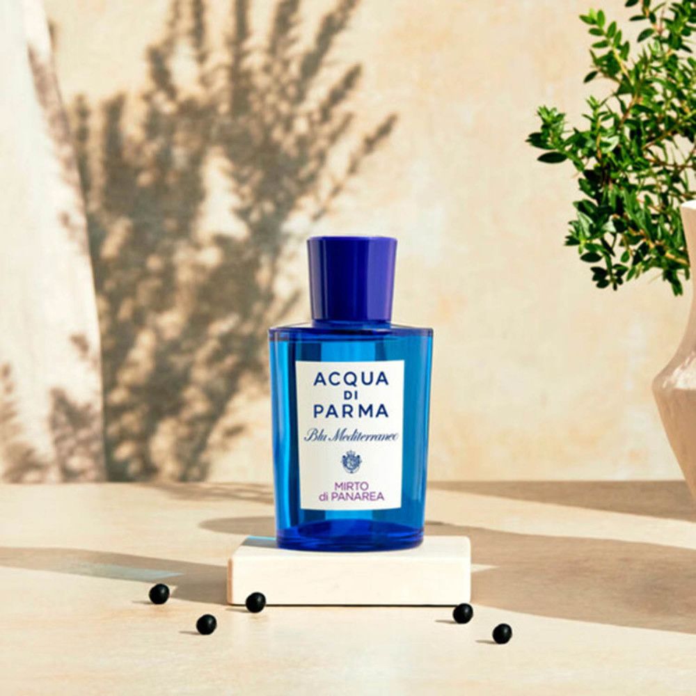 Flacon de parfum bleu sur un socle. Inscription: ACQUA DI PARMA Blu Mediterraneo Mirto di Panarea. Avec décoration.