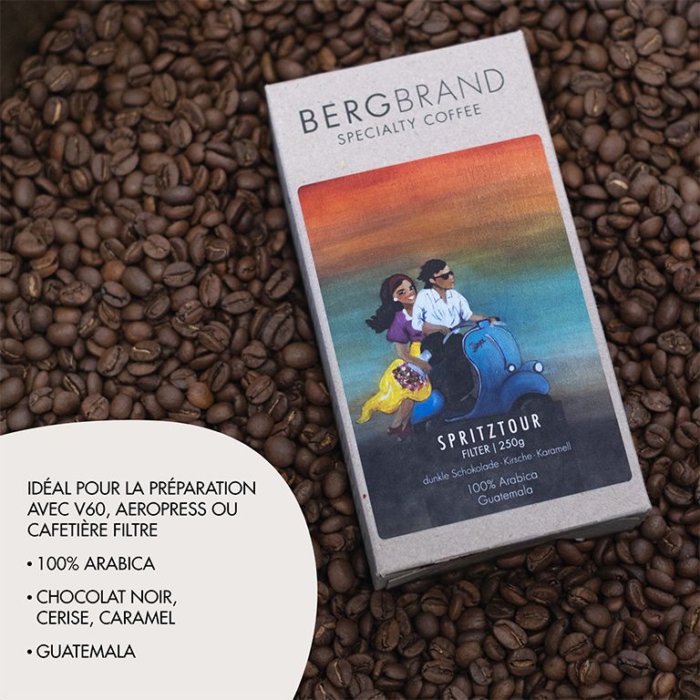 Boîte BERGBRAND Specialty Coffee Spritztour sur grains de café. Boîte avec illustration de scooter. Texte.