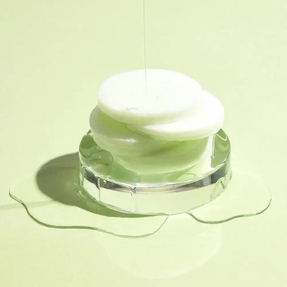 Disques verts empilés sur un support transparent. Liquide qui coule sur les disques.