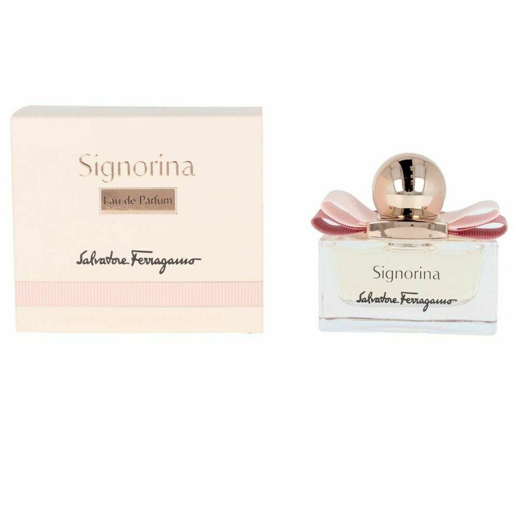 Signorina Eau de Parfum Spray. Rechthoekige glazen fles met roze vloeistof, roze strik en gouden dop. Verpakking ernaast.