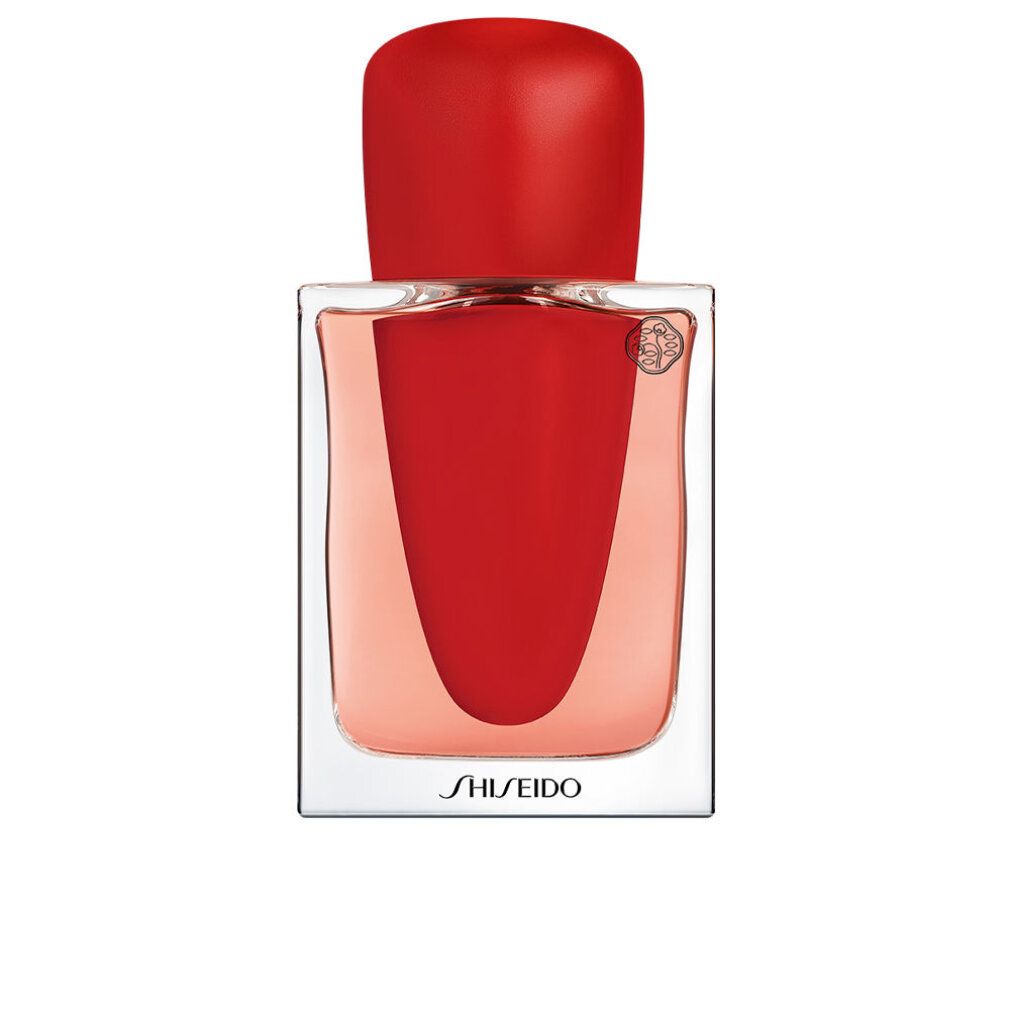 Fles met rode dop en rode vloeistof. Transparant glas. Opschrift: Shiseido. Logo.