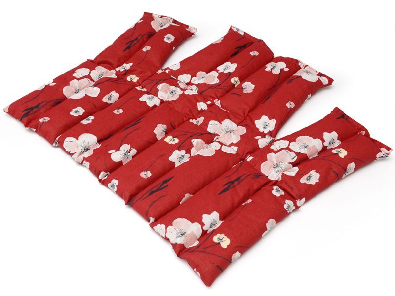 Compresse anatomique rouge, motif floral blanc. Plusieurs compartiments, forme rectangulaire.