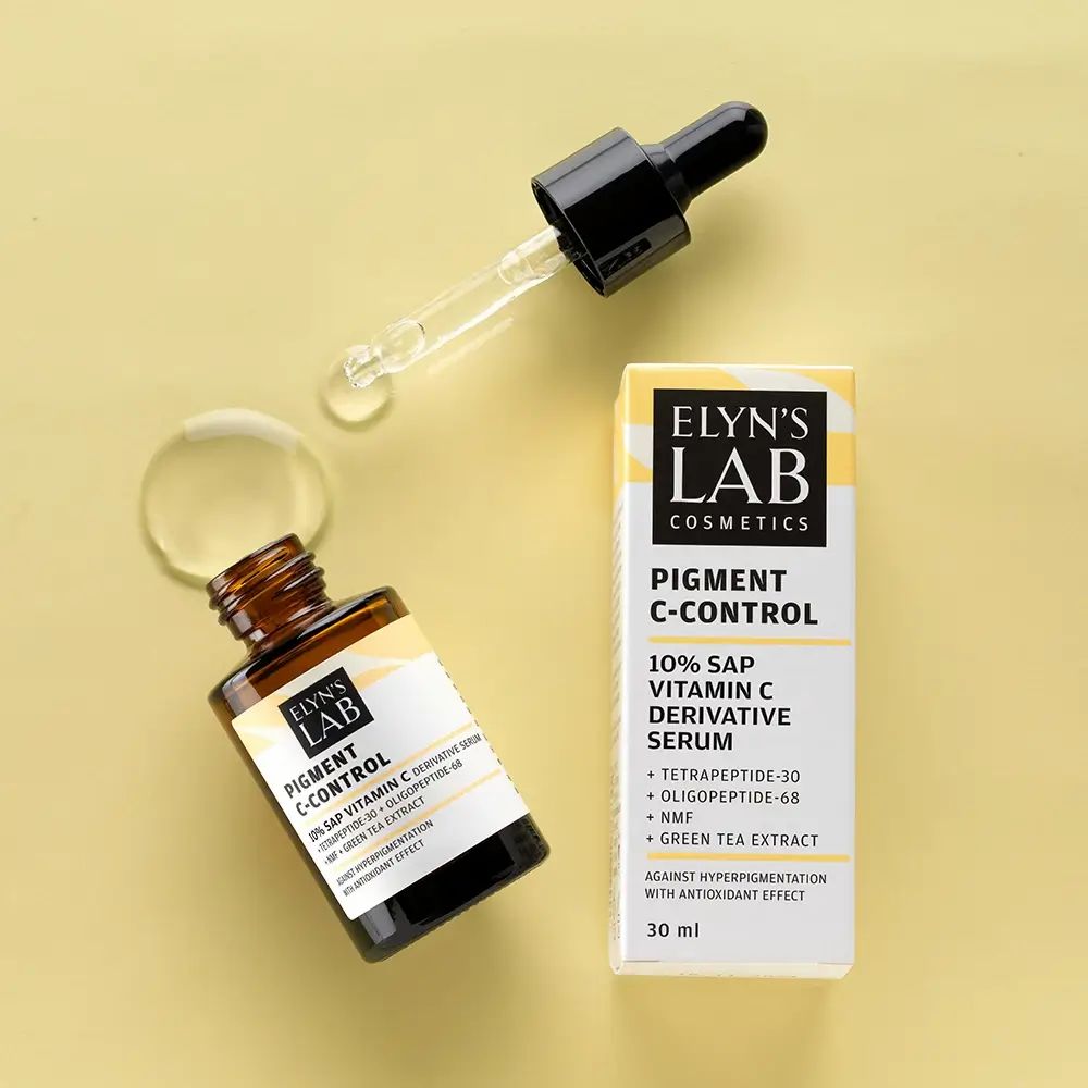 Serumfles en verpakking. Pipet ernaast. Productnaam en ingrediënten op het etiket. ELYN'S LAB Pigment C-Control Serum.