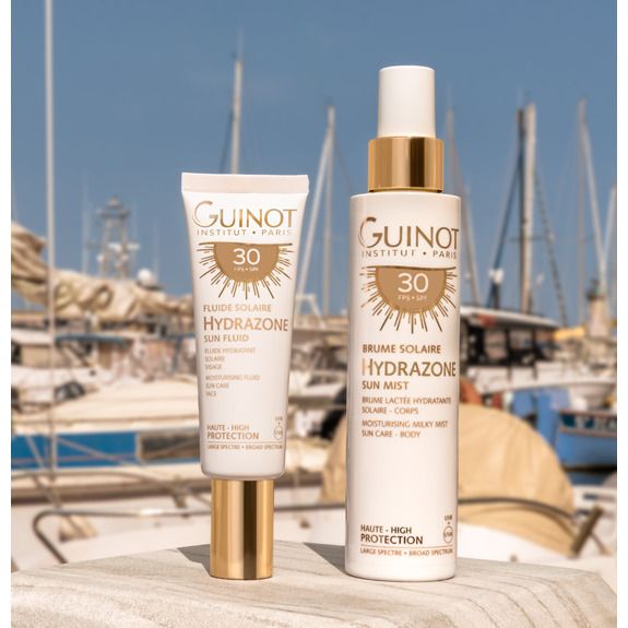 Twee zonnebrandproducten. Links tube, rechts sprayfles. Beide met opschrift 'Hydrazone' en '30 SPF'.