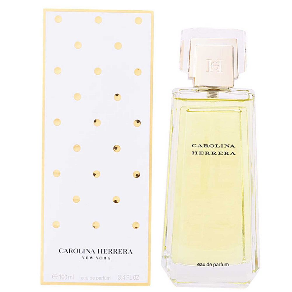 Parfumfles en verpakking. Fles rechthoekig, transparant. Verpakking wit met gouden stippen. Opschrift: CAROLINA HERRERA.