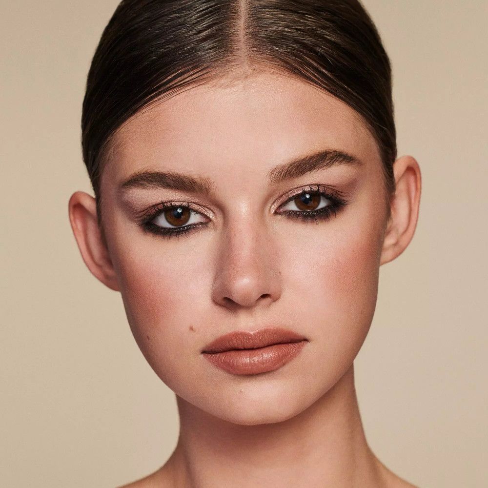Close-up van een gezicht met make-up. Bruine oogschaduw, lippenstift. Huidtint.