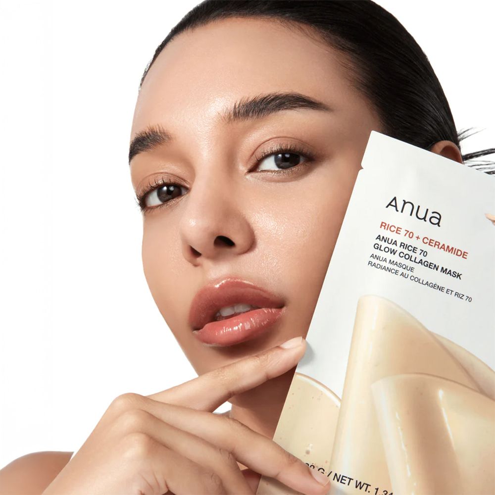 Vrouw houdt een Anua Rice 70 Glow Collagen masker voor haar gezicht.
