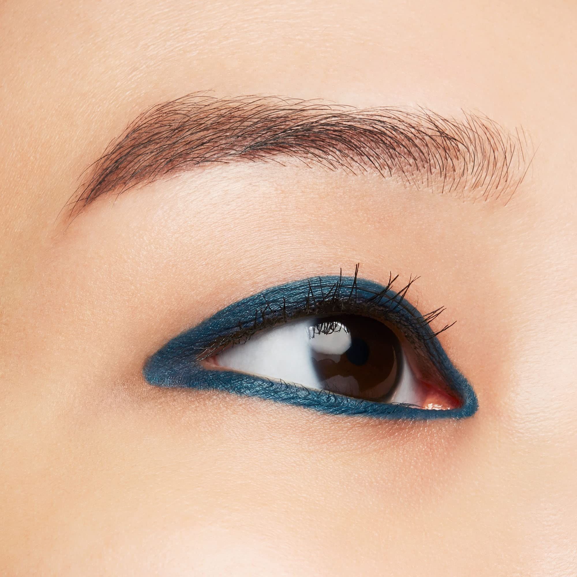Gros plan sur un œil avec Shiseido Eye Microliner Ink 08 en Teal sur les paupières supérieure et inférieure. Peau et sourcils bruns.
