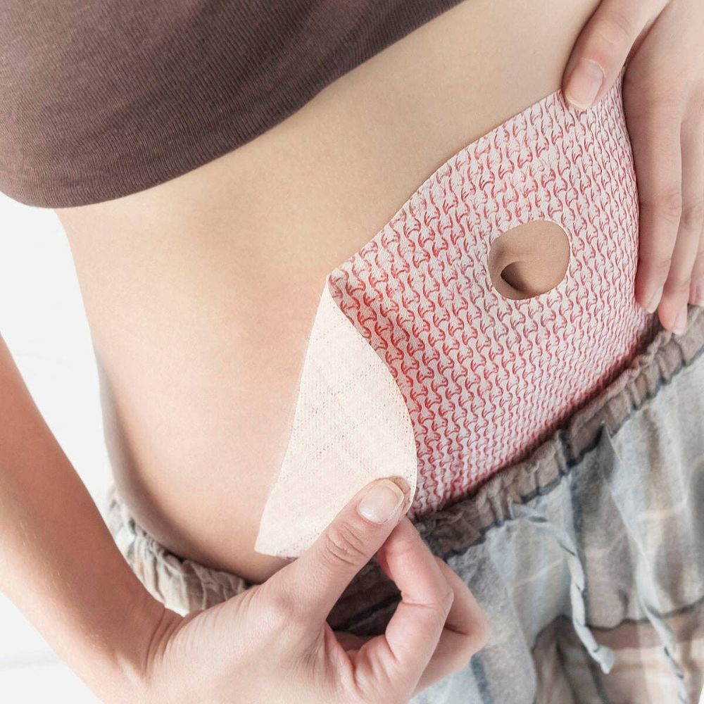 Personne appliquant un patch amincissant. Le patch est rose avec un motif rouge et un trou.