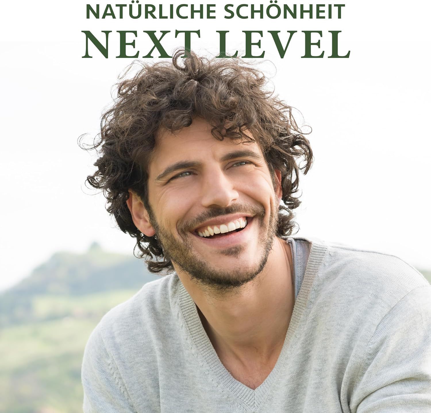 Een lachende man voor een groen landschap. Tekst: NATÜRLICHE SCHÖNHEIT, NEXT LEVEL.