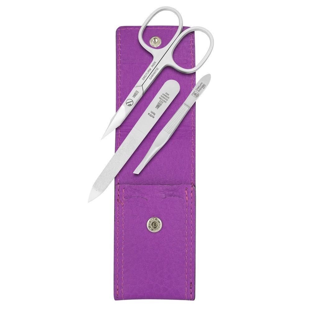 Étui de manucure violet avec ciseaux, lime et pince à épiler. Outils en métal. Étui avec bouton-pression.