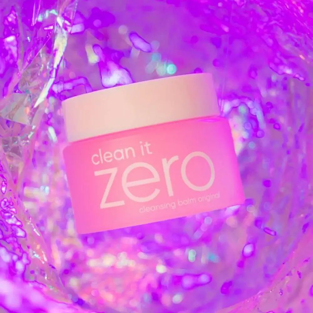 Pot rose avec couvercle blanc. Inscription : clean it zero cleansing balm original. Sur fond irisé.