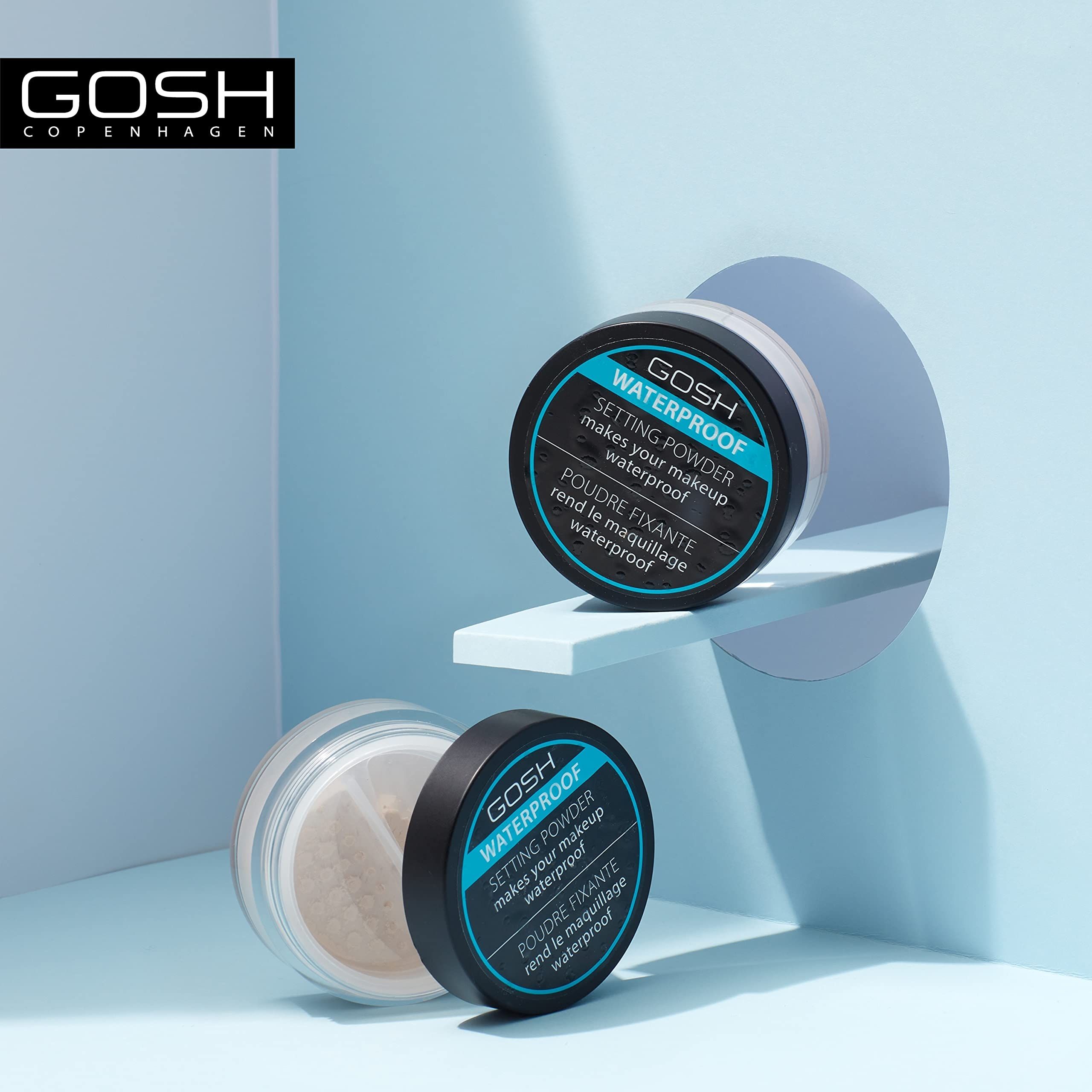 Deux boîtes GOSH WATERPROOF SETTING POWDER. Une ouverte. Sur fond bleu. Inscription sur les couvercles.
