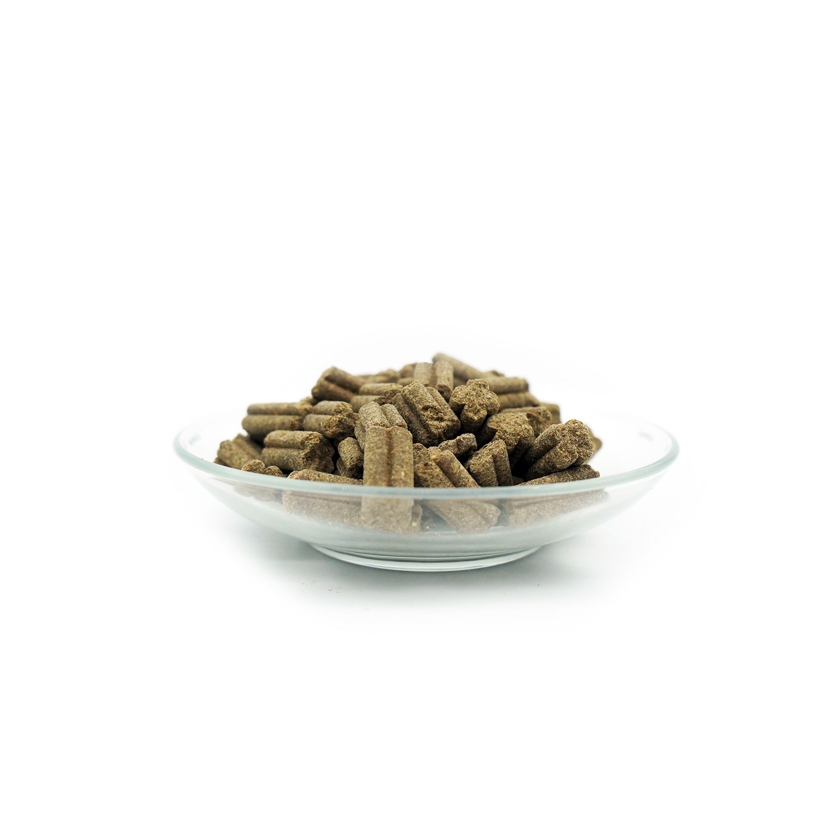 Transparante glazen schaal gevuld met bruine, langwerpige droogvoer pellets. Op witte achtergrond.