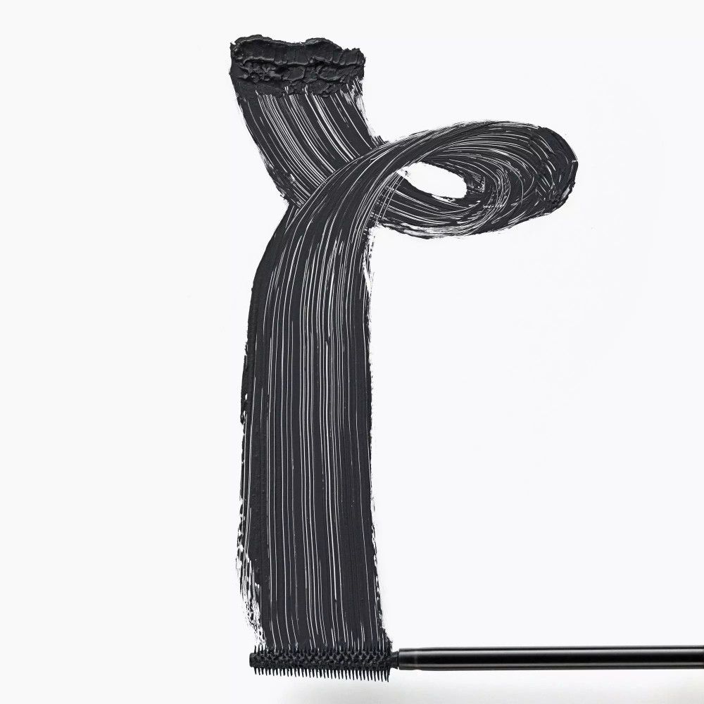 Texture de mascara noir sur fond blanc, appliquée avec une brosse. Forme : Y.