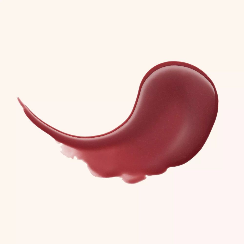 Tache de baume à lèvres étalée, ton rosé foncé, sur fond clair.