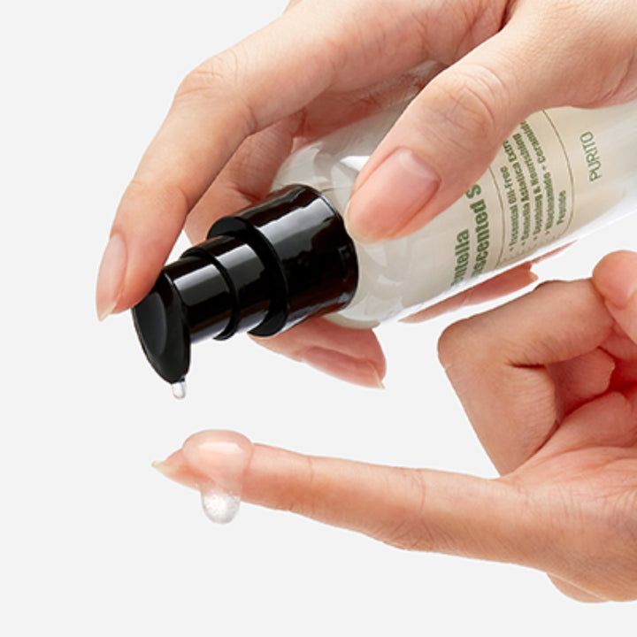 Hand die serum op vinger drukt. Druppel serum op vinger. Lichte achtergrond.