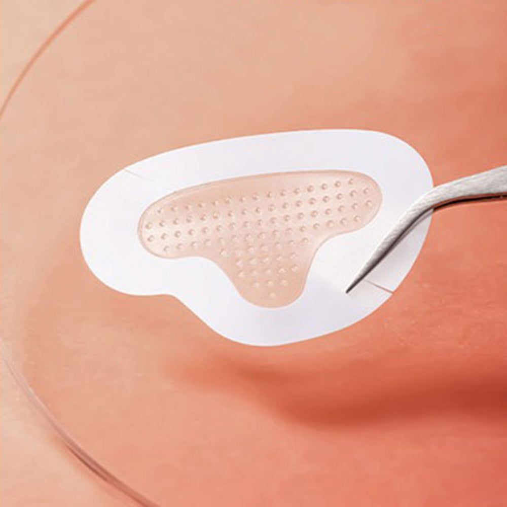 Close-up van een ACROPASS Reti-Rn Mikrokegel-Pflaster T-Shape patch. Patch met microkegelstructuur. Pincet houdt de patch vast.