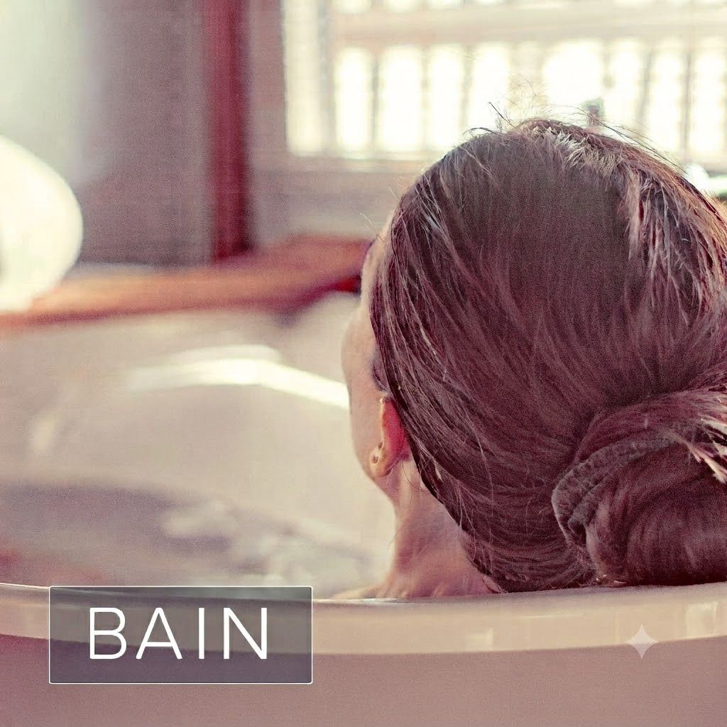 Femme aux cheveux attachés se relaxant dans une baignoire. Texte 'BAIN' en bas à gauche.