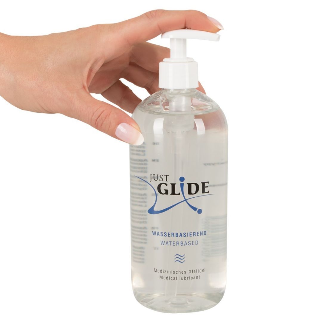 Hand houdt een transparante fles met pomp vast. Productnaam en tekst. Watergebaseerde glijmiddel. Medische benaming.