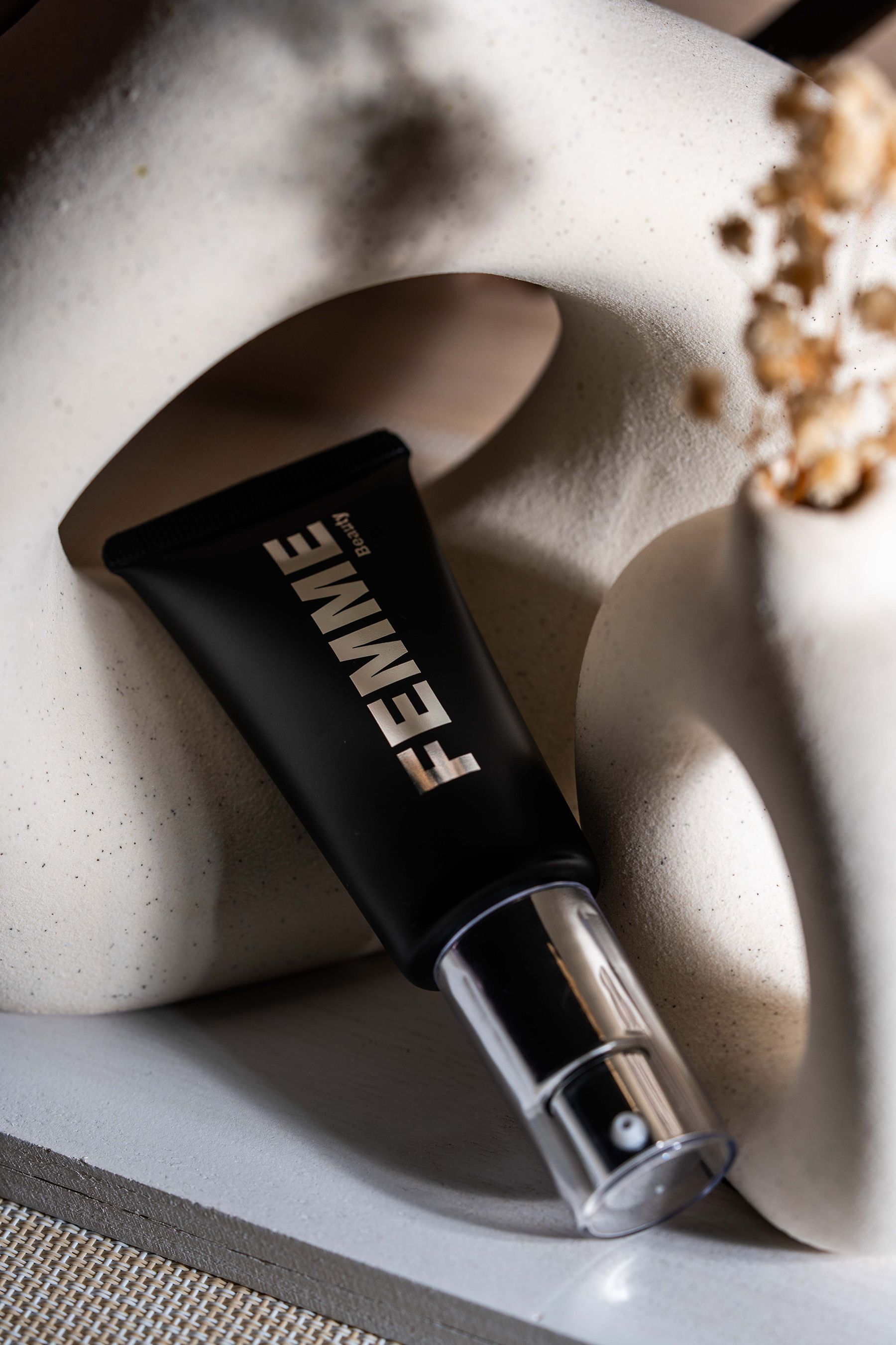 FEMME Intense Hide Concealer, tube noir avec distributeur argenté, posé en biais.