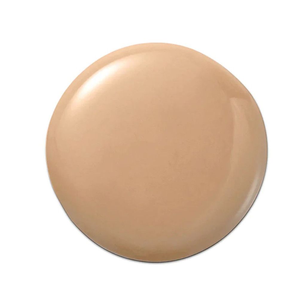 Goutte de fond de teint liquide clair sur fond blanc. Forme ronde avec surface brillante.