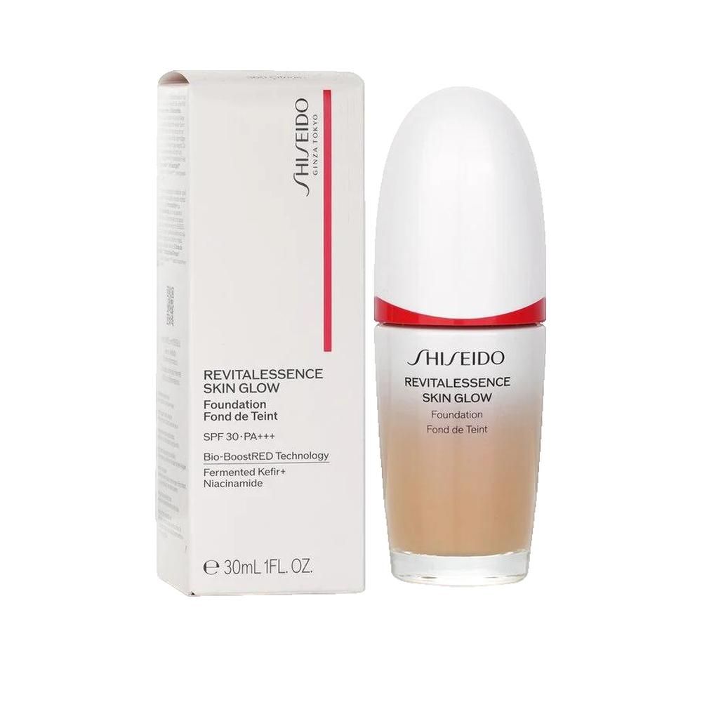 Shiseido Revitalessence Skin Glow Foundation avec emballage. Flacon blanc, bouchon blanc, anneau rouge. Texte: SPF 30, 30ml.