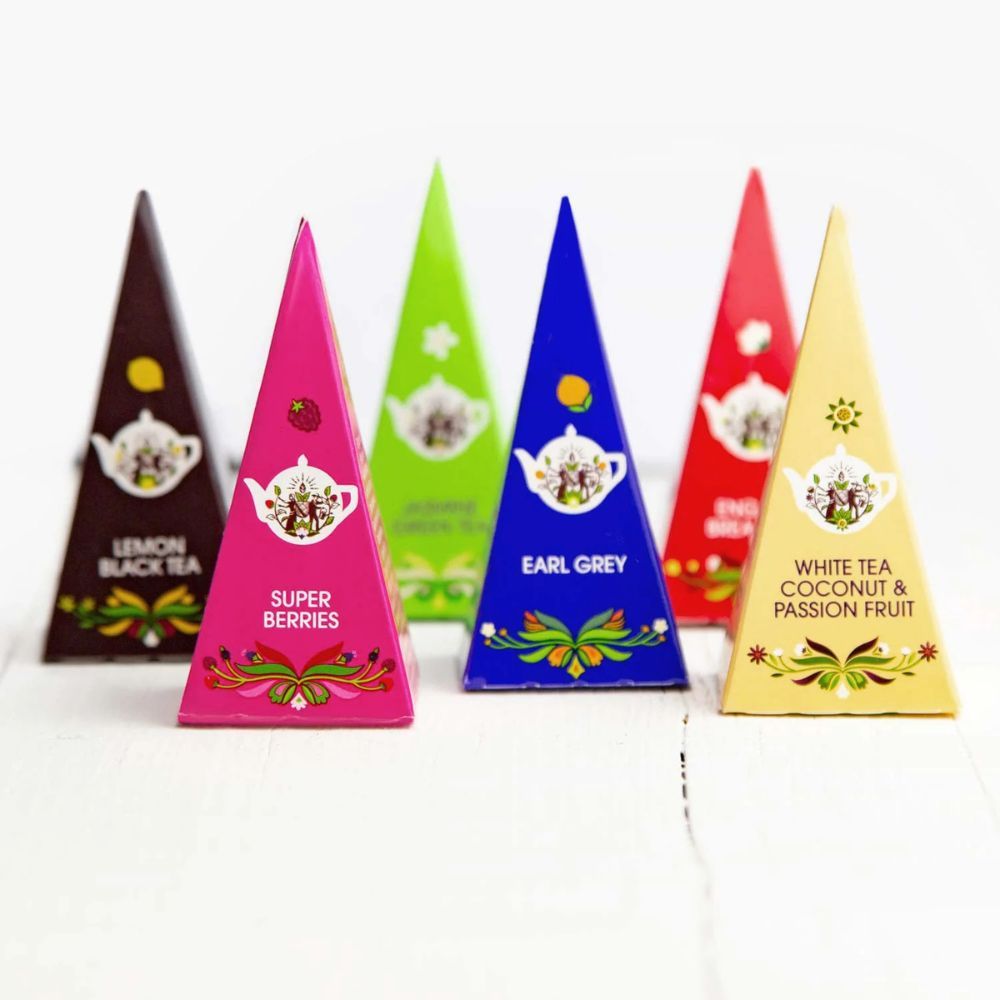 Zes gekleurde piramideboxen met thee. Opschriften: Lemon Black Tea, Super Berries, Earl Grey, White Tea Coconut & Passion Fruit.