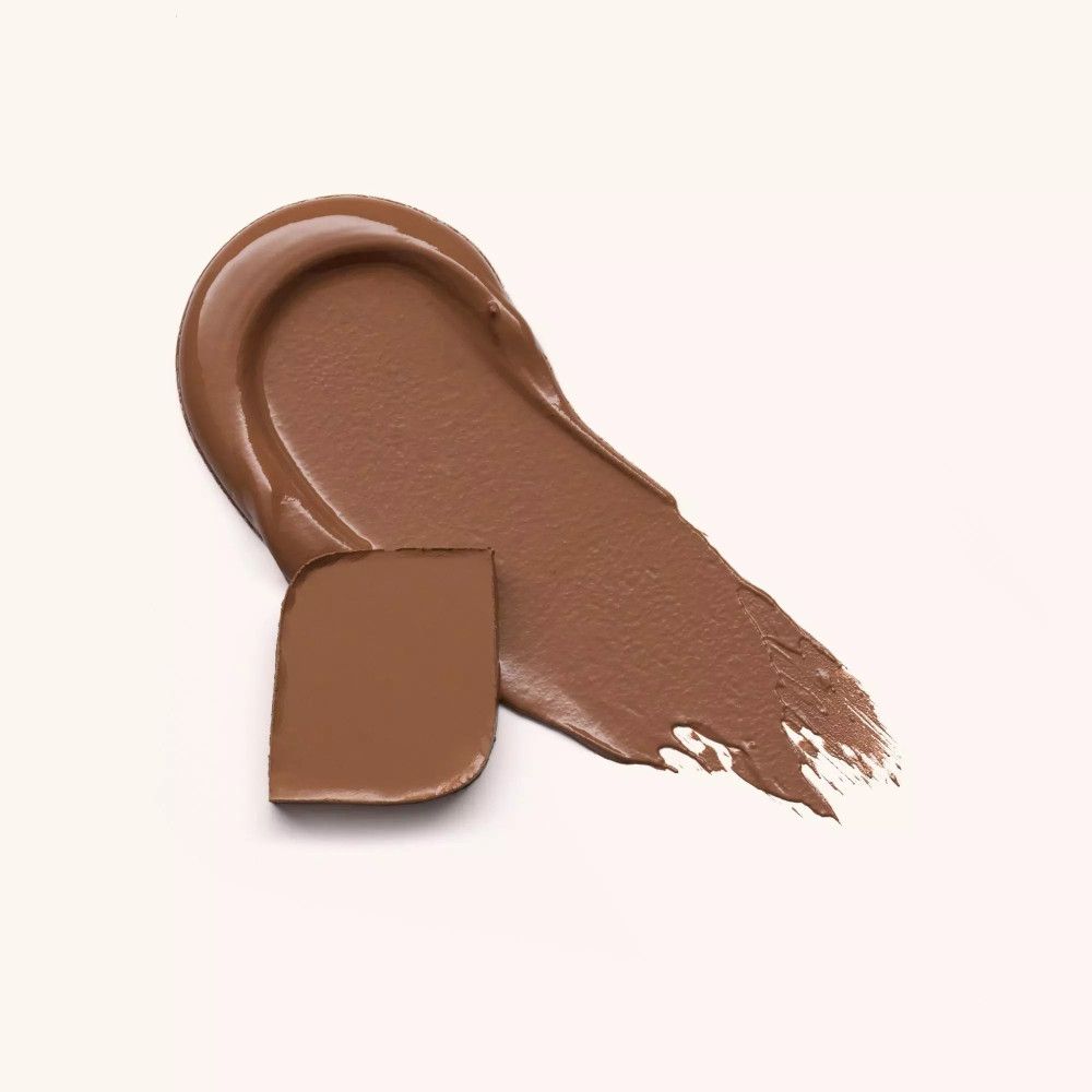 Étalement de bronzer crème brun avec une touche carrée à côté. Sur fond blanc.