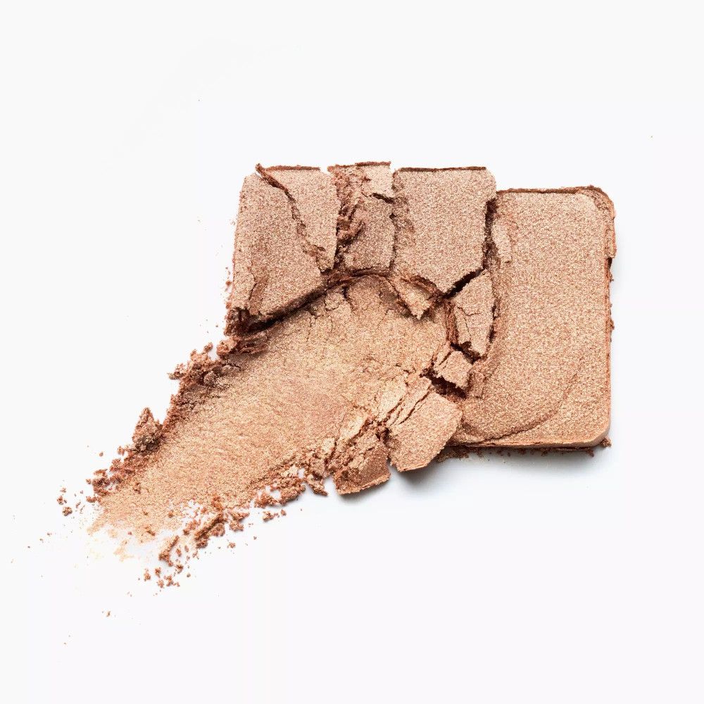 Fard à paupières doré, cassé. Trace de couleur. Sur fond blanc.