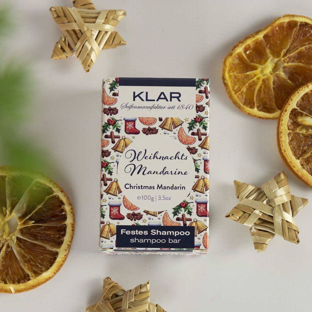 Emballage Klar, shampooing solide Weihnachtsmandarine, entouré de décorations.