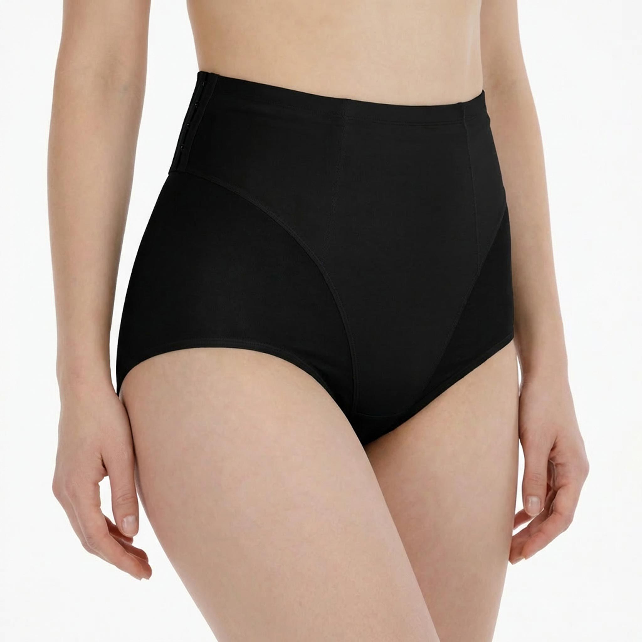 Culotte noire taille haute, empiècements latéraux. Femme de face, taille et ventre visibles.