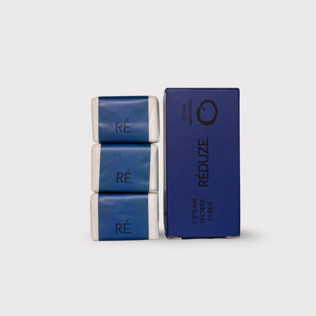 3 douchecubes en een doos. Opschrift: RÉ, 3 Steam Shower Cubes, Cedar Mandarin.