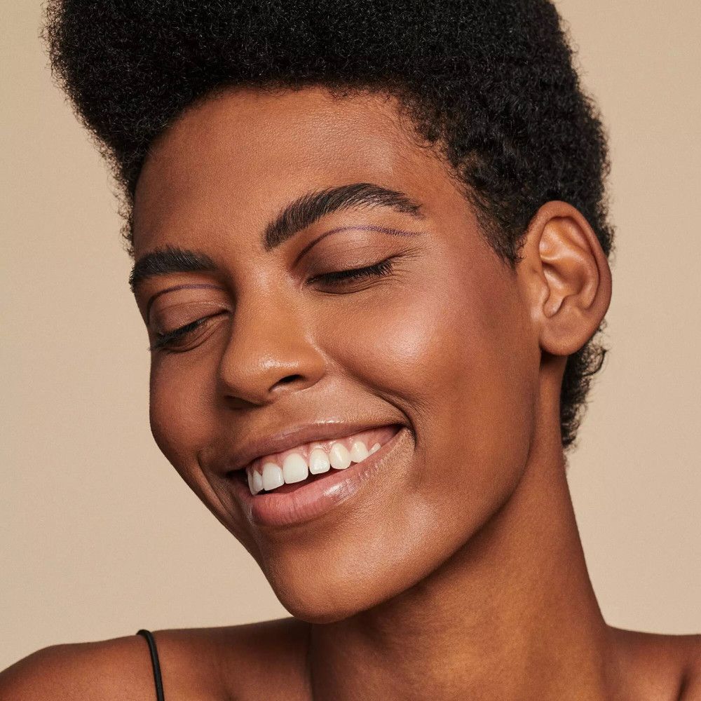 Portrait d'une femme les yeux fermés et souriante. Teint clair.