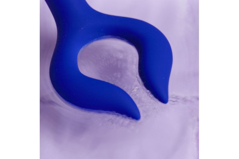 Stimulateur bleu avec deux extrémités incurvées. Produit placé dans un liquide.