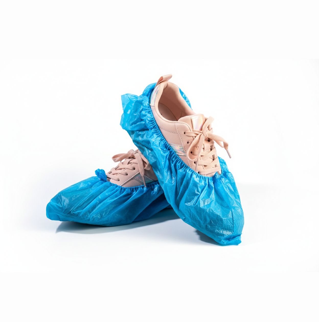 Blauwe overschoenen over schoenen. De overschoenen zijn van glanzend materiaal.