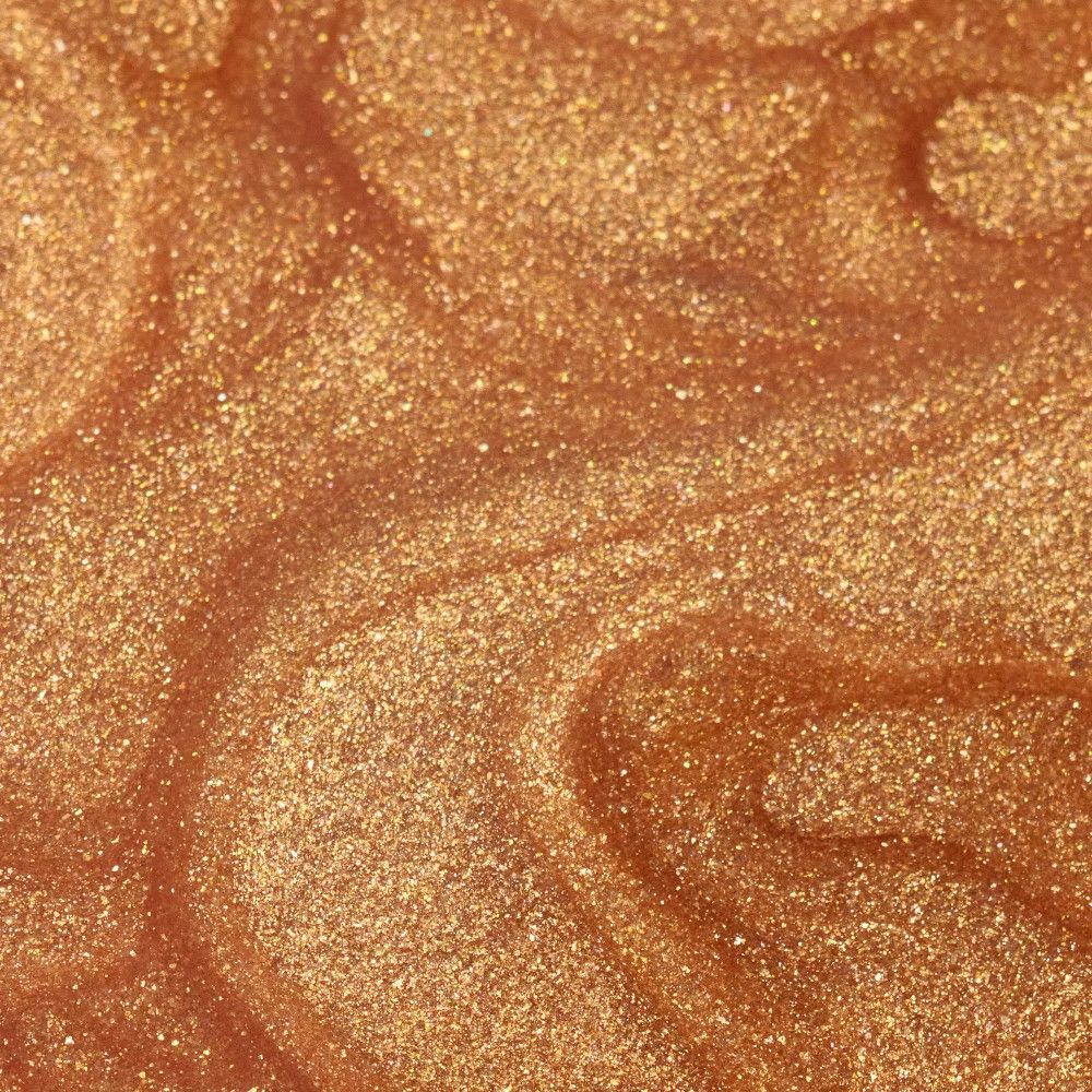 Gros plan sur de l'huile sèche dorée. Particules scintillantes et texture visibles.