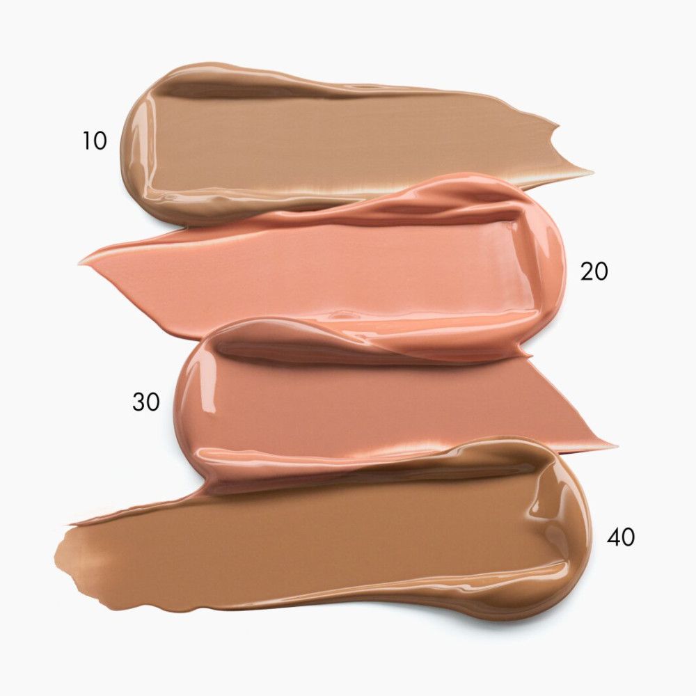 Quatre échantillons de maquillage liquide dans différentes teintes de peau : beige clair (10), rose (20), pêche (30), brun foncé (40).