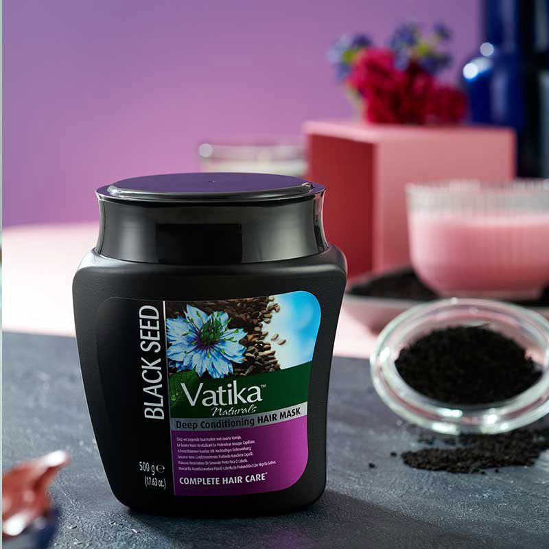 Zwart haarmasker met etiket. Opschrift: Vatika Naturals, Deep Conditioning Hair Mask. Illustratie van zwarte komijnzaad. 500g.