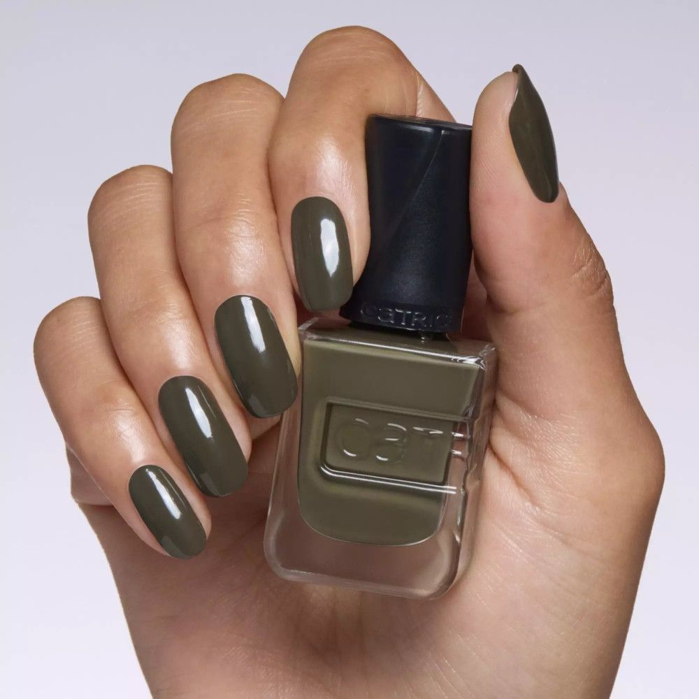 Main avec ongles vernis en vert olive. Flacon de vernis à ongles avec logo de la marque.
