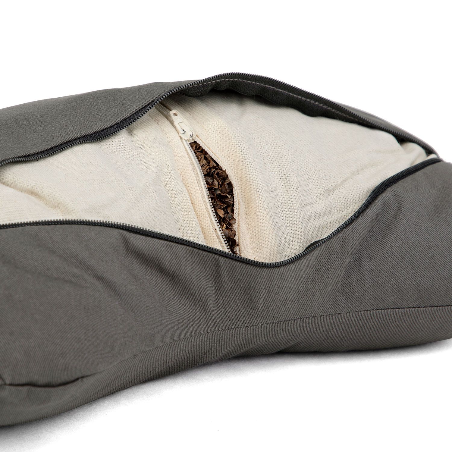 Coussin de méditation avec fermeture éclair ouverte, montrant la doublure claire et le remplissage de cosses de sarrasin.