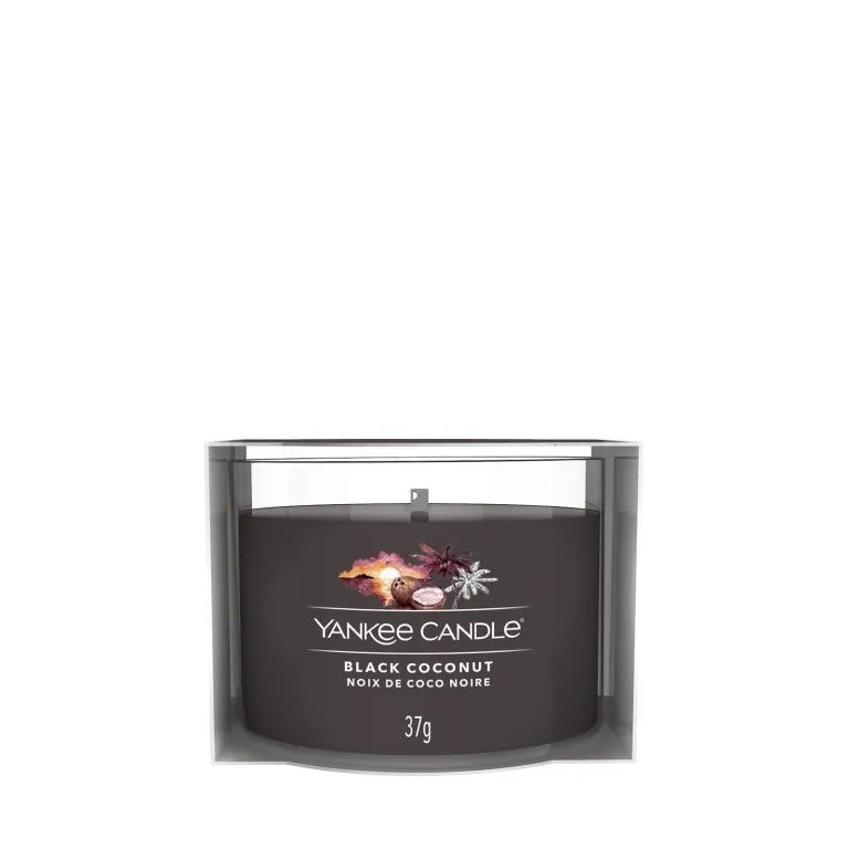 Bougie noire dans un contenant transparent. Inscription : Yankee Candle, Black Coconut, Noix de Coco Noire, 37g.