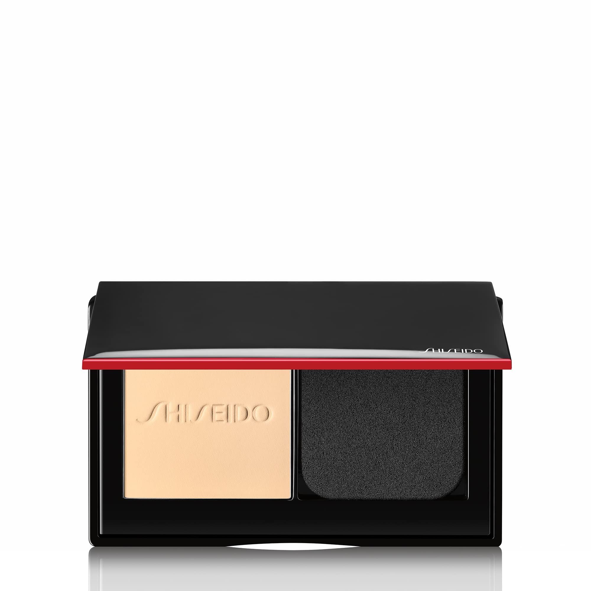 Poudre compacte avec miroir et applicateur. Boîtier noir avec accent rouge. Marque Shiseido.