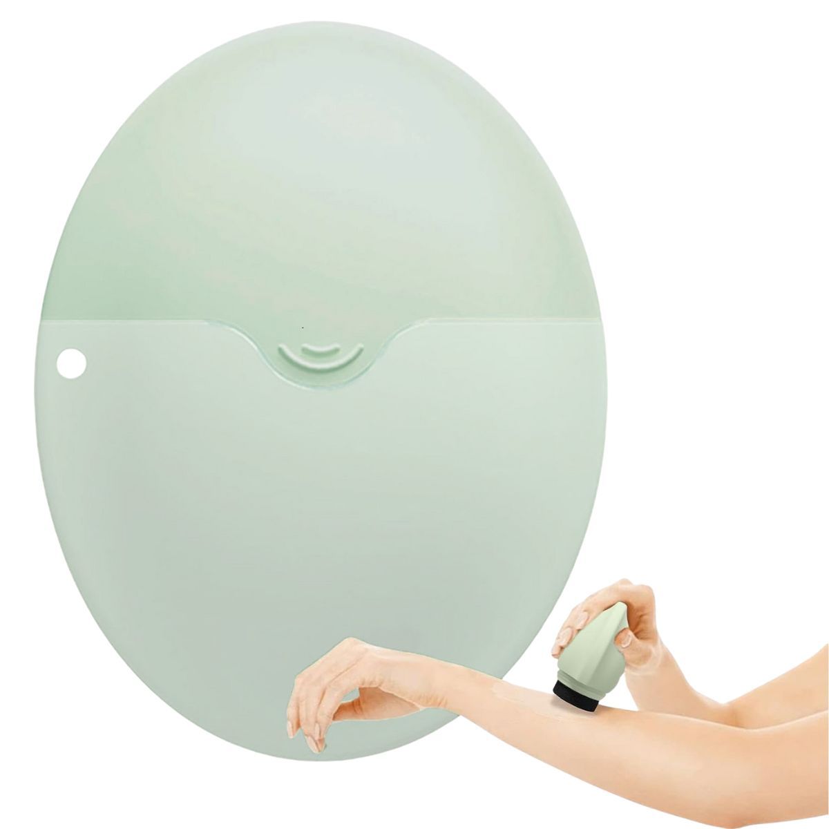 Applicateur vert clair en cours d'utilisation. Une main tient l'applicateur, l'autre le frotte sur le bras. Le produit est en silicone.