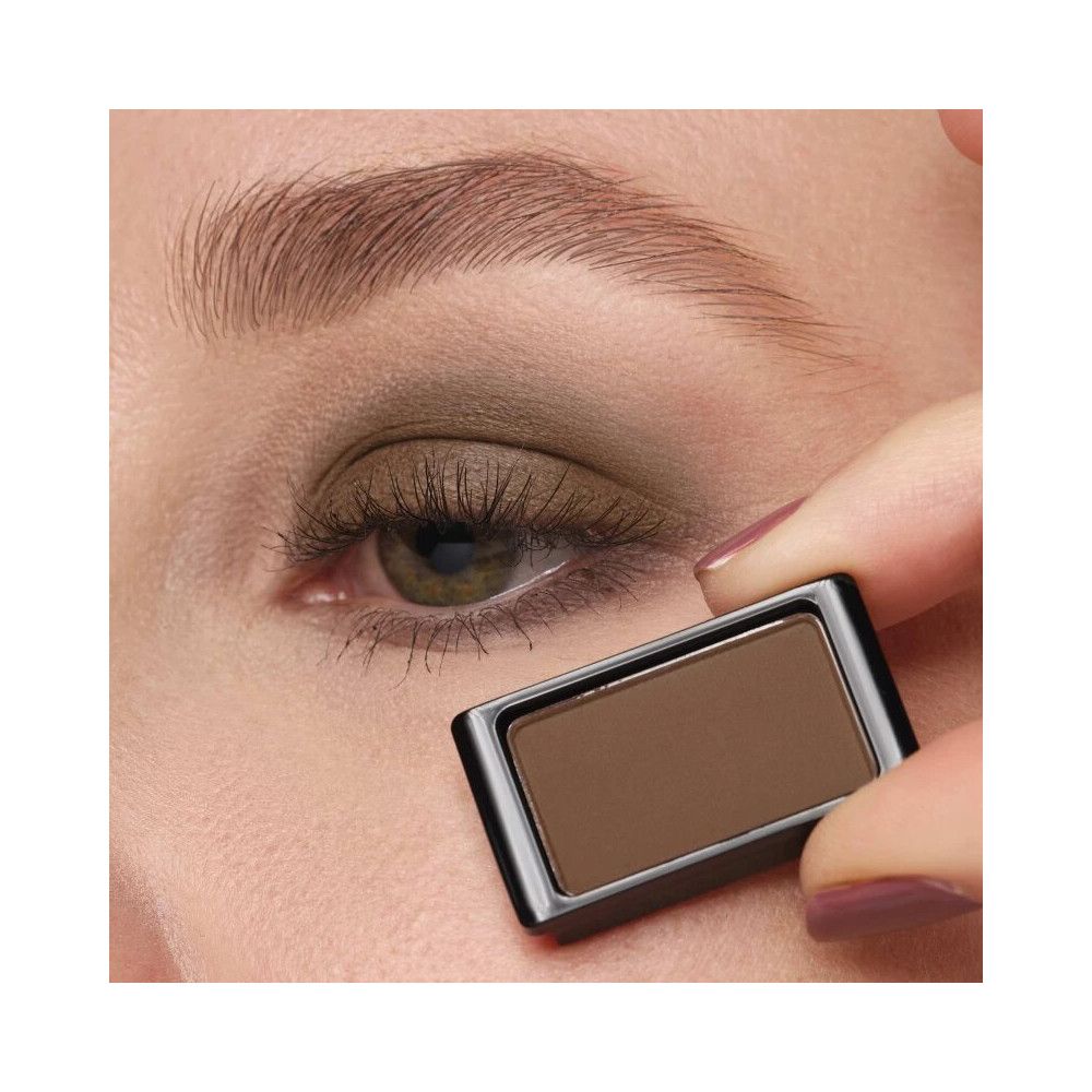 Fard à paupières Dunkelgrau Mocha. Forme rectangulaire, dans un boîtier noir. Tenu devant un œil.