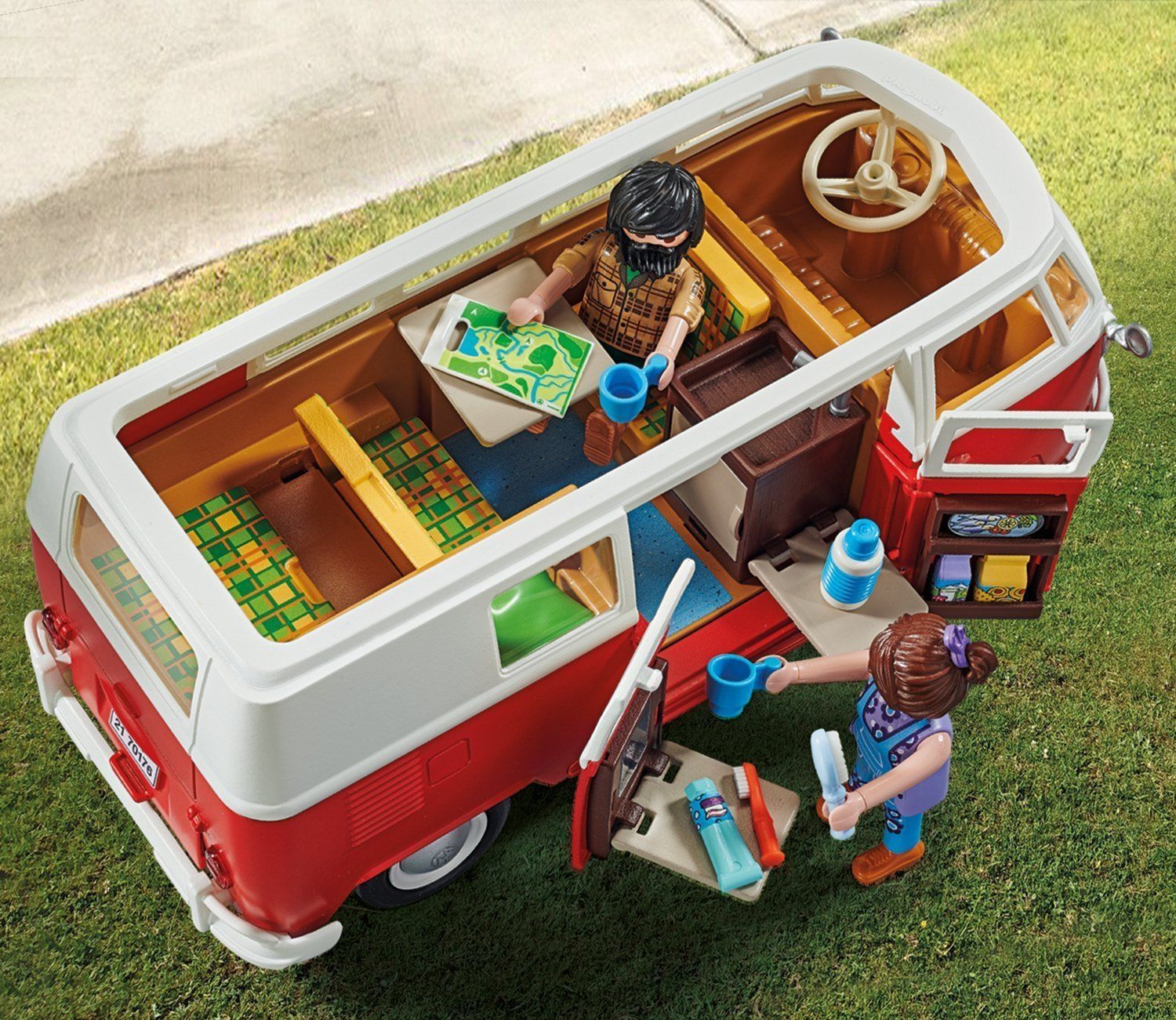 Vue intérieure d'un bus VW jouet rouge et blanc avec figurines et accessoires. Portes ouvertes.