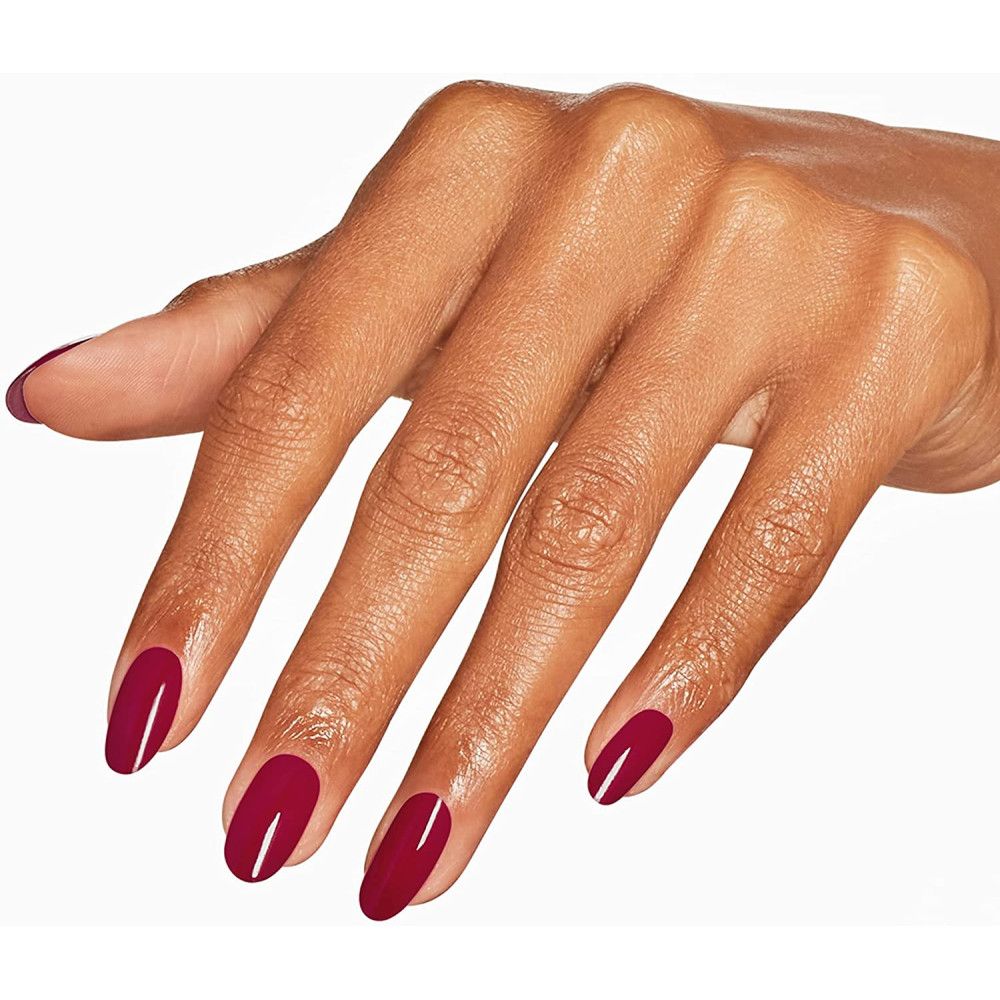 Hand met gelakte nagels in dieprood. Ovale vorm. Huidskleur.