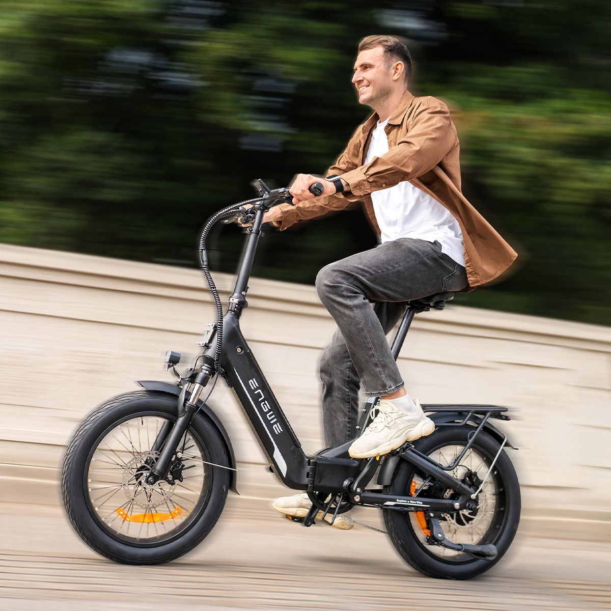 Man rijdt op een zwarte elektrische fiets. Het ENGWE-logo is zichtbaar. De achtergrond is wazig.