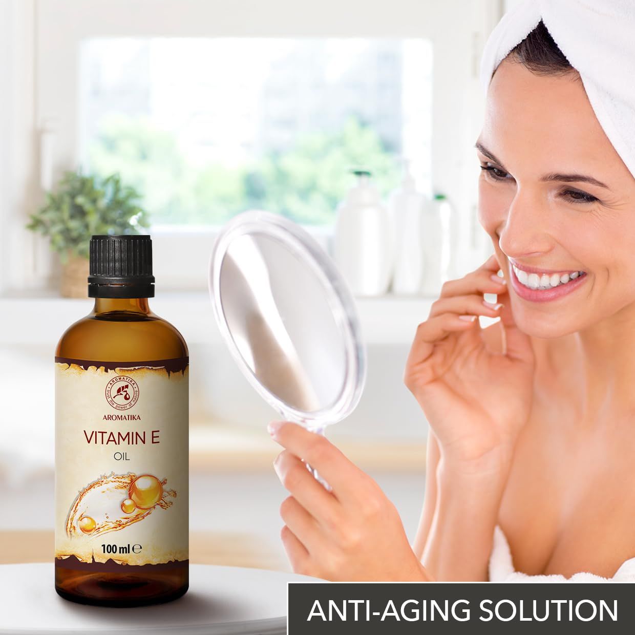 Vrouw bekijkt zichzelf in spiegel, naast AROMATIKA Vitamine E Olie fles. Tekst "Anti-Aging Solution".