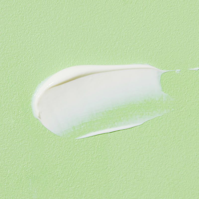 Vlek crème op groene achtergrond. Textuur zichtbaar.